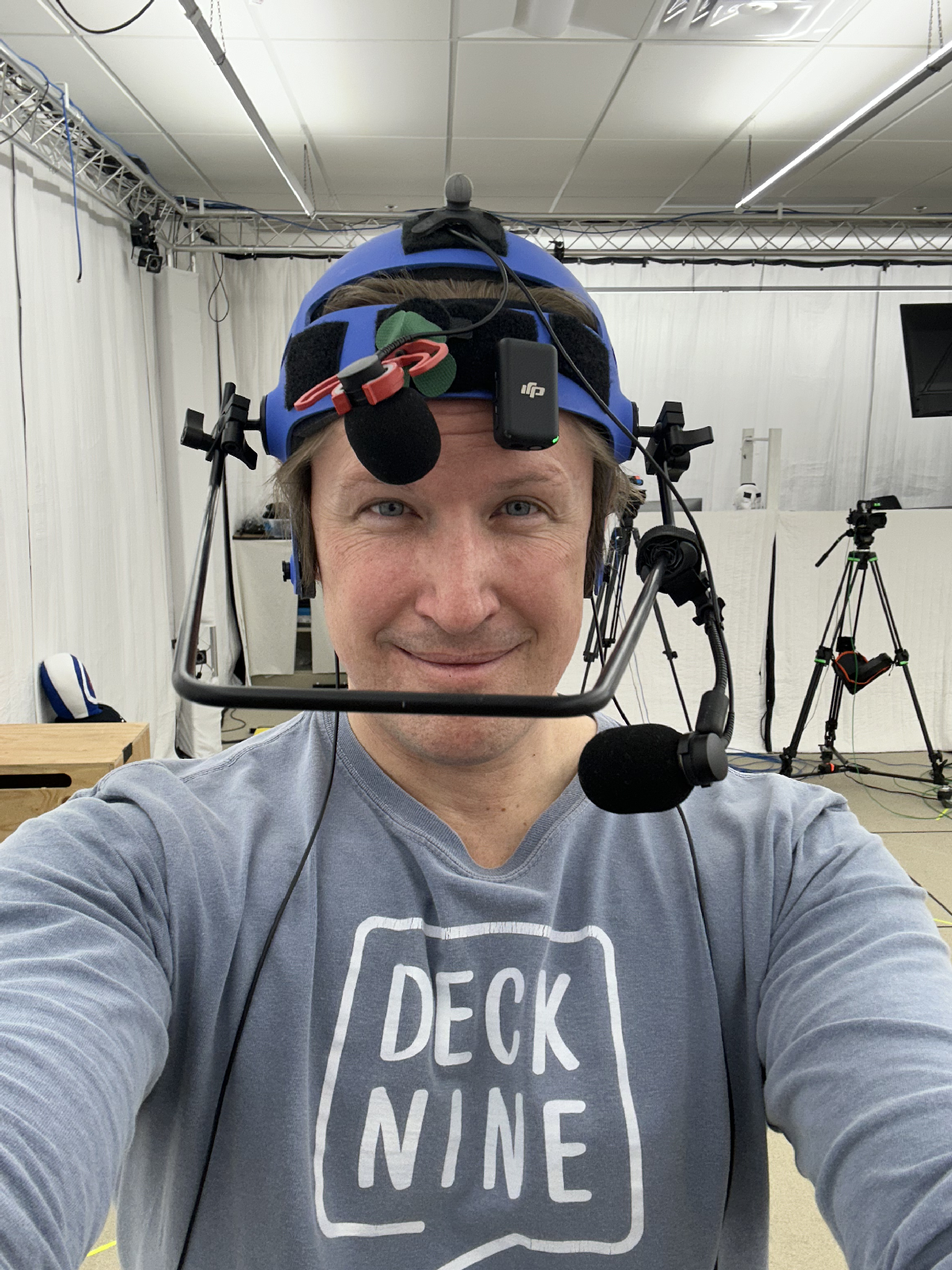 Zachary Andrews on the Deck Nine mocap stage, wearing a Deck Nine shirt and head-mounted face camera